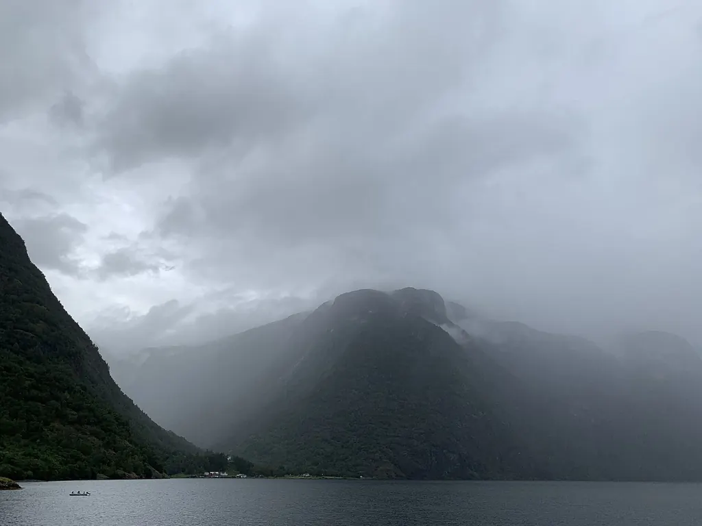 Tief hängende Regenwolken verhüllen die Berge über dem grauen Nærøyfjord