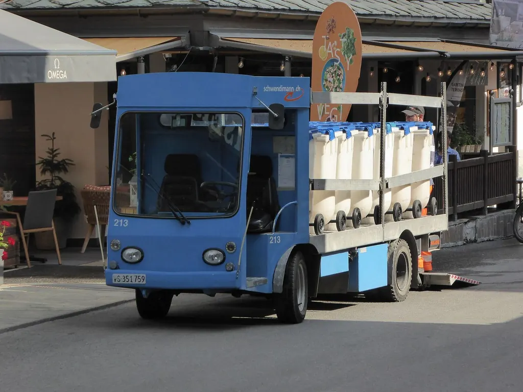 Ein kleines blaues Elektrofahrzeug auf der Bahnhofstrasse im autofreien Zermatt
