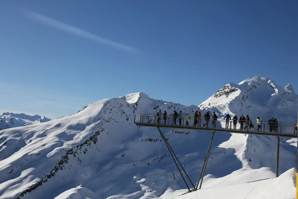 Besucher auf der Aussichtsplattform des First Cliff Walk über verschneiten Hängen bei Grindelwald