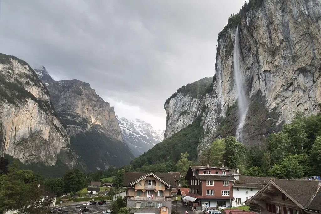 Der Staubbachfall stürzt über die Felswand hinter den Holzhäusern von Lauterbrunnen