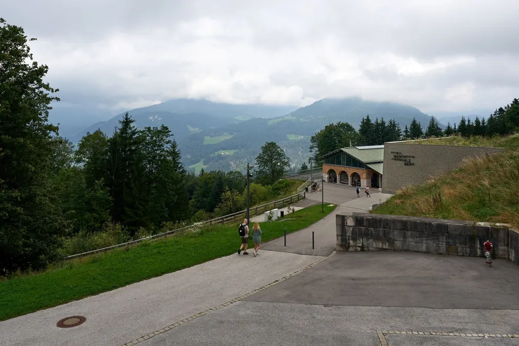 Gelände am Obersalzberg mit dem Gebäude der Dokumentation, Fußwegen und Blick über das Tal unter tiefen Wolken