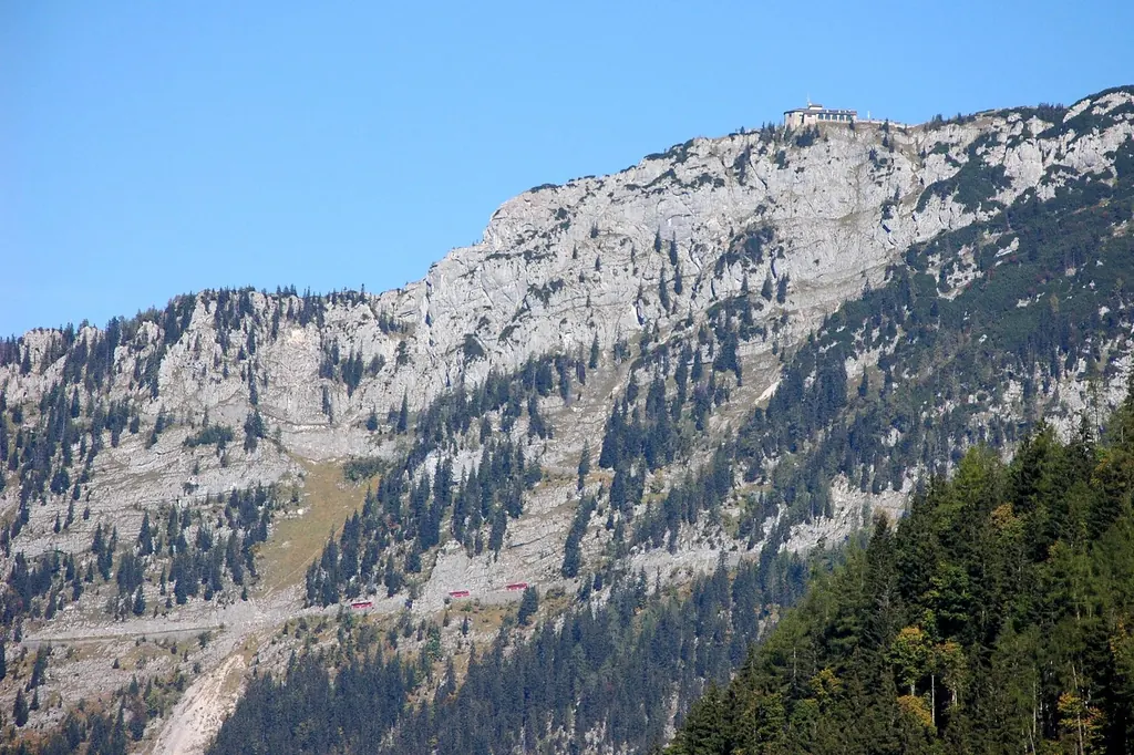 Blick aus dem Tal auf die Felswand des Kehlsteins, ganz oben klein das Kehlsteinhaus, in der Wand die Trasse der Kehlsteinstraße