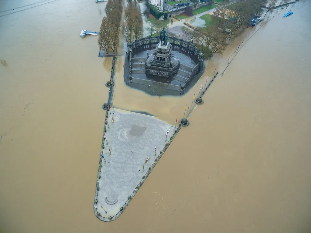 Drohnenaufnahme bei Hochwasser: Die Spitze des Deutschen Ecks mit dem Denkmal ragt als schmales Dreieck aus braunem Wasser
