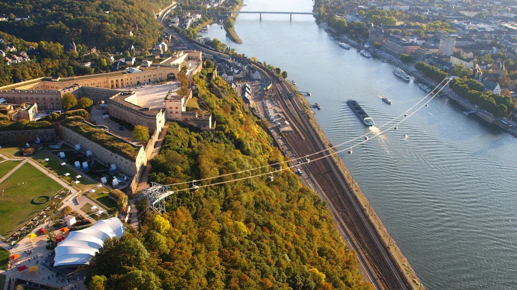 Aerial view: the cable car arcs across the Rhine, the sprawling Ehrenbreitstein Fortress on the left, the town on the right