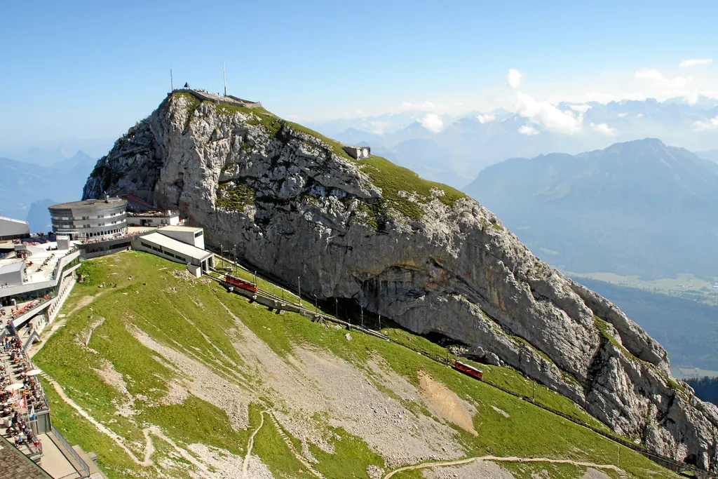 Der Gipfelgrat des Pilatus von oben: das Hotel Pilatus Kulm, die Bergstation und die Zahnradbahn, die auf der grünen Flanke ankommt