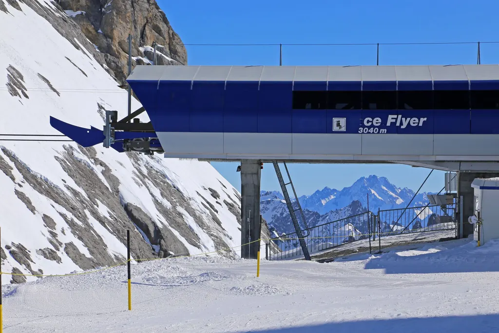 Die Bergstation des Sessellifts Ice Flyer auf 3.040 m am Titlis im Schnee, dahinter verschneite Gipfel